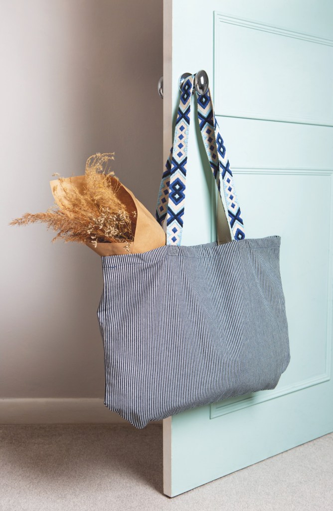 Image shows a tote bag hanging on a door knob