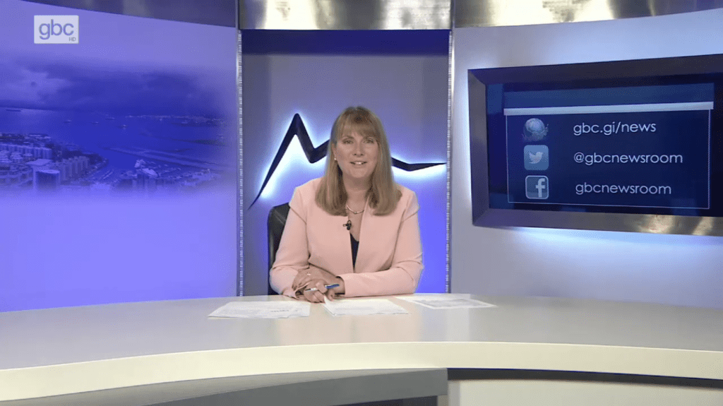 Image shows Lindsay Weston sitting behind the news reading desk at GBC News 